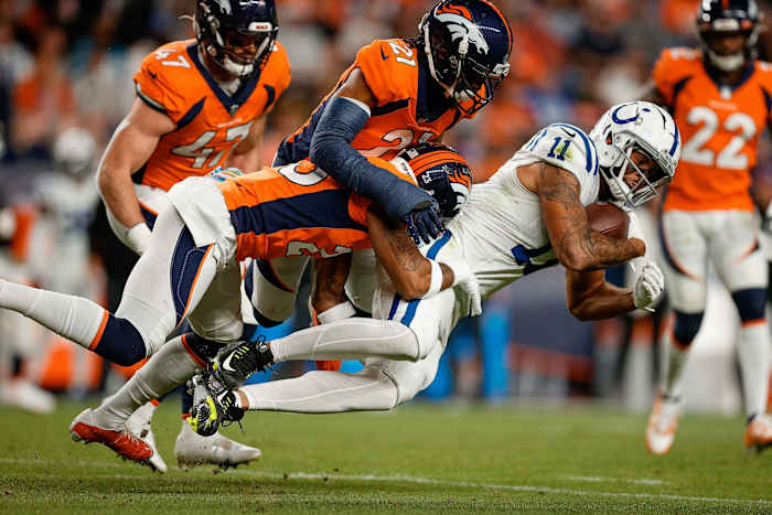 Indianapolis Colts wide receiver Michael Pittman Jr. (11) is tackled by Denver Broncos cornerback Ronald Darby (23) and cornerback K'Waun Williams (21) in the second quarter at Empower Field at Mile High.